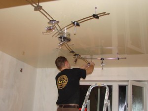 Процесс установки нескольких светильников на потолке
