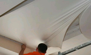 Процесс монтажа пленки на потолок